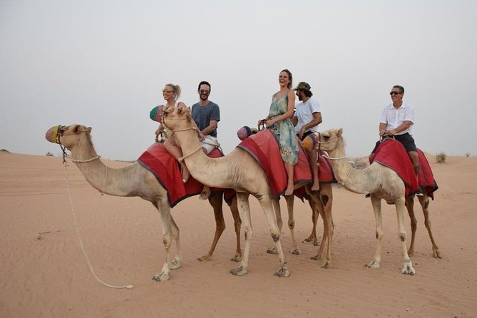 Classic Dubai Desert Safari with BBQ Dinner and Camp activities - Sunset at the camp, with sandboarding and henna
