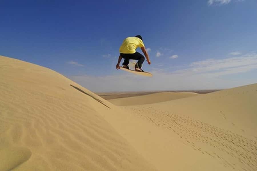 Desert Safari, Quad Bike, Camel Ride, Falcon & Sandboarding - Sandboarding from a high dune