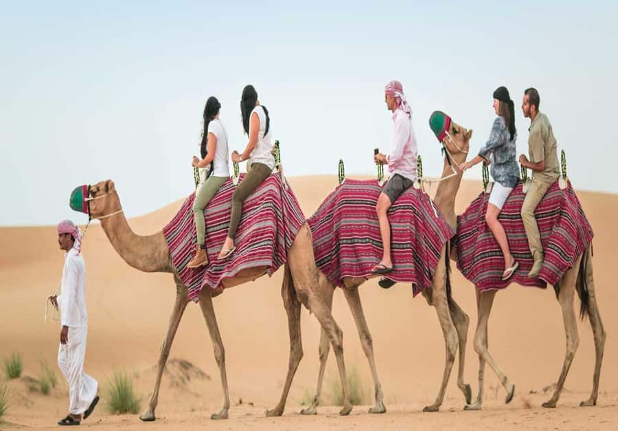Dubai: Desert Safari, Camel Ride, Sandboard & Buffet Dinner - Sandboarding for first-timers