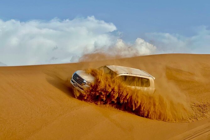 Dubai Desert Safari: Dune Bashing, Camel Ride, Sandsurf & 5<em> BBQ – Key points to know before booking’ /></p>
<ul>
<li><strong>Lahbab’s red dunes provide the main thrill:</strong> Expect a longer dune-bashing ride, a sandboarding stop, and time for photos.</li>
<li><strong>Ahmed and Ali are named guides:</strong> Driver care is an important part of the experience, especially during the dune ride.</li>
<li><strong>The camp adds culture after the action:</strong> Henna, Arabic clothing, falcon photos, camel feeding, coffee, dates, and sweets are included.</li>
<li><strong>Dinner comes with several shows:</strong> Your buffet meal is paired with Tanoura, belly dance, fire, and Ladies Khaliji performances.</li>
<li><strong>The $27.91 price covers a lot:</strong> Pickup, transport, activities, soft drinks, dinner, and entertainment are included.</li>
<li><strong>Optional costs can change the total:</strong> Quad biking costs $50, while shisha and VIP seating are not included.</li>
</ul>
<h2>Red dunes first, camp later</h2>
<p><img width="669" height="446" decoding="async" src=