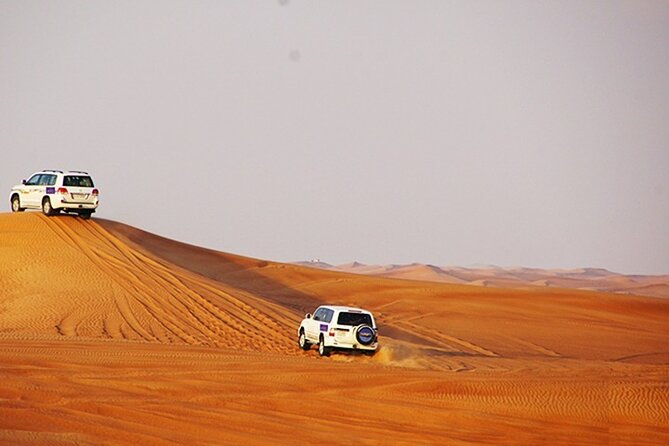 Dubai Desert Safari with BBQ, 3 Shows & Camel Ride at Majlis Camp - Desert stops, sunset, and sandboarding